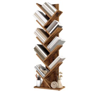 Angled wooden bookshelf filled with neutral-colored books, with pencils, headphones, a clock, and a vase at the base.