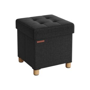 Dark gray, square tufted ottoman with short wooden legs and fabric upholstery.